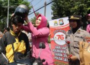 Sapa Warga di Hari Jadi ke -76, Polwan Polrestabes Surabaya Turun Jalan Berbagi Helm dan Bunga